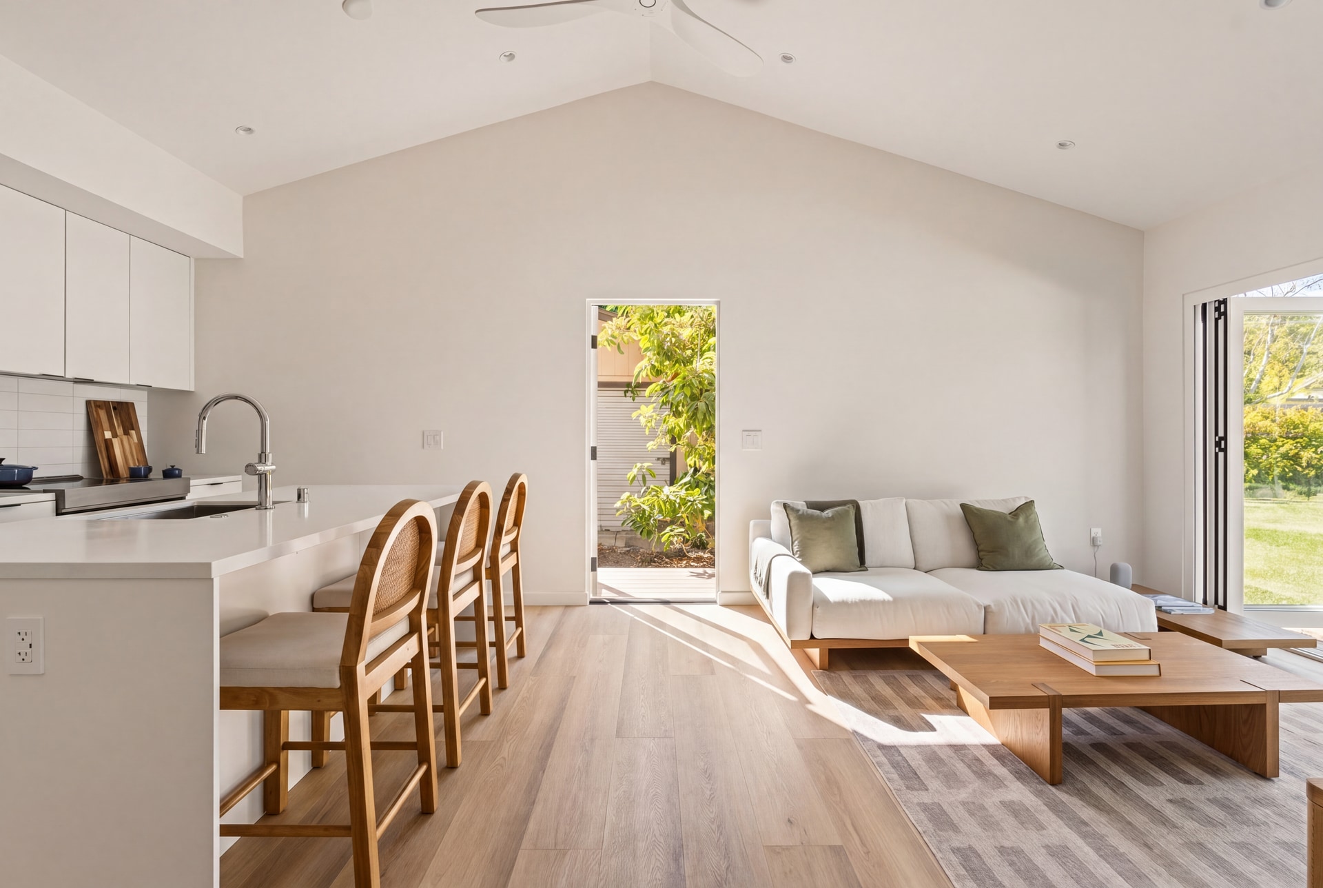 Inside a Buildoly Model 2 ADU — vaulted ceilings, kitchen, and folding glass doors open to garden